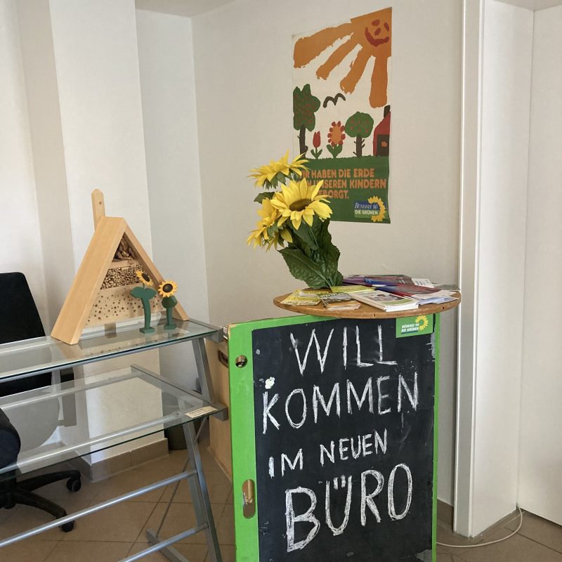 Büroeröffnung Bündnis 90 / Die Grünen Regensburg-Stadt; Tafel mit der Aufschrift "Willkommen im neuen Büro", Sonnenblumen, Insektenhotel